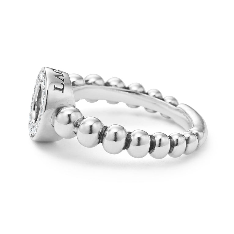 A side-view of a sterling silver ring is displayed on a white background featuring diamond circle detailing the LAGOS logo sits on a tapered Caviar beaded band