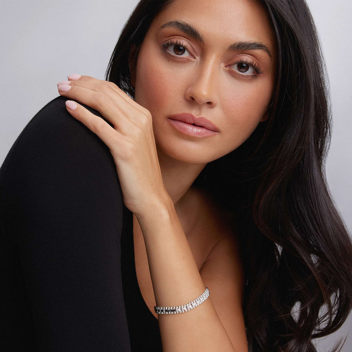 A woman wearing a sterling silver link bracelet in the middle of a white background featuring diamonds framed by sterling silver Caviar beading