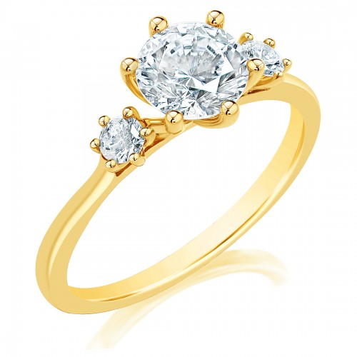 A close-up of a ring made of yellow gold, angled to the right against a white background. It features a round-cut diamond set in the center with side stones.