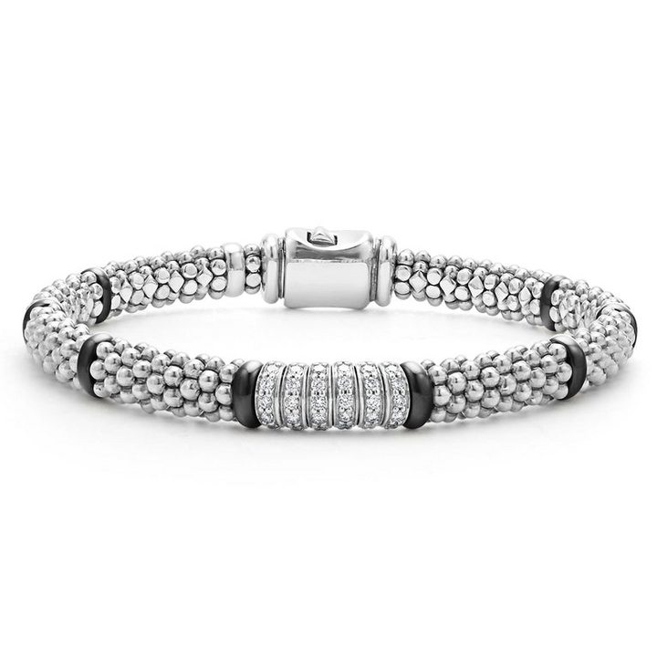 A sterling silver bracelet in the middle of a white background features smooth black stations, diamond-set stations, and ceramic caviar beading.