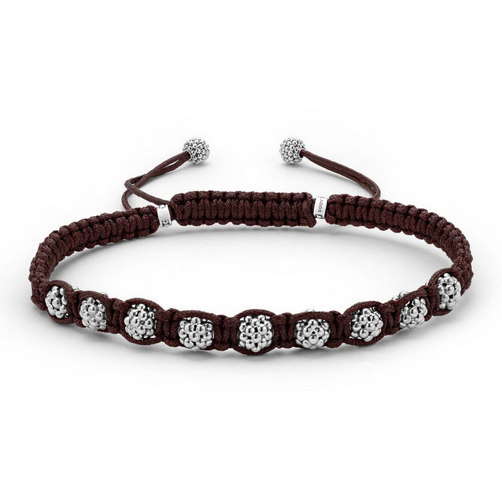 A brown bracelet is in the middle of a white background, featuring braided nylon and silver Caviar beads.