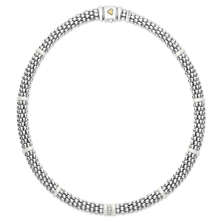 A sterling silver and 18k gold necklace in the middle of a white background featuring white stations, one diamond set station, and caviar beading.