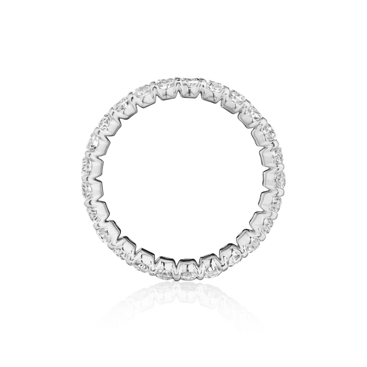 Close-up photo side-view of a white gold women's wedding band with oval cut diamonds and diamond set band on a white background