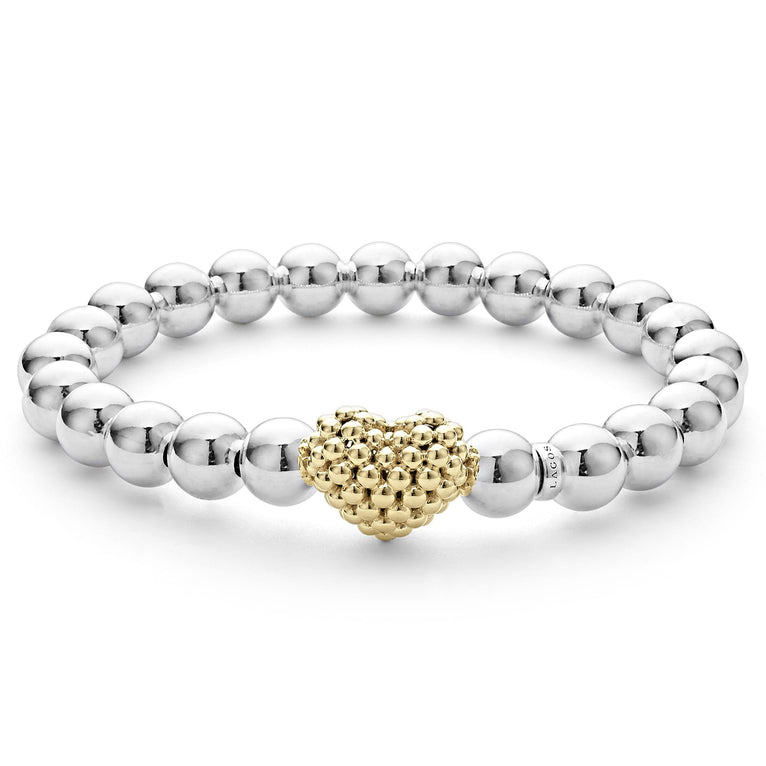 A sterling silver and 18k gold beaded bracelet in the middle of a white background featuring an 18k gold and silver Caviar beaded heart accent