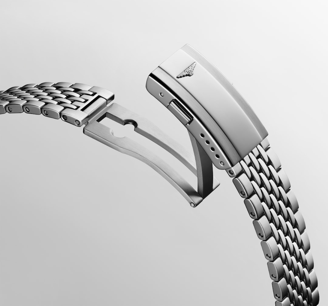 A close-up of a Longines watch angled showing the stainless steel bracelet and undone clasp. The Longines logo is on the top of the clasp.