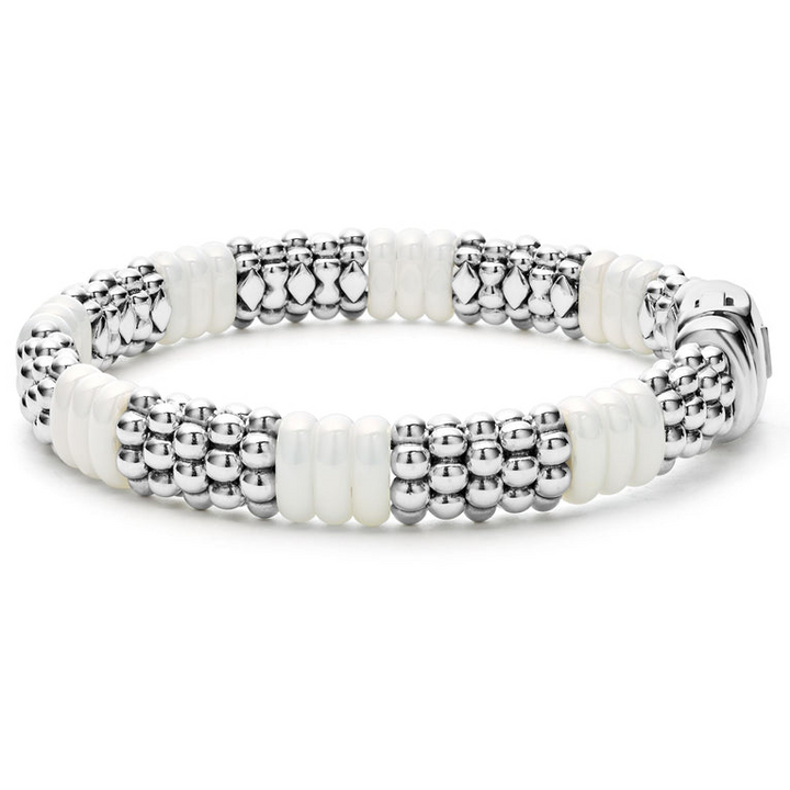 A sterling silver beaded bracelet standing vertically in the middle of a white background, featuring Sterling silver Caviar beading and smooth white ceramic