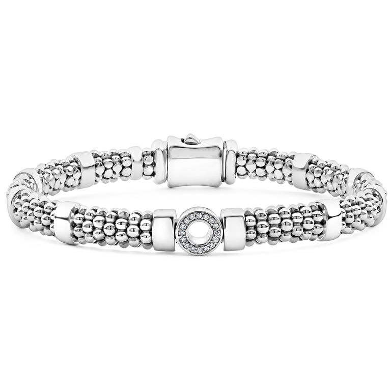 A sterling silver bracelet in the middle of a white background featuring one diamond circle station and caviar beading.