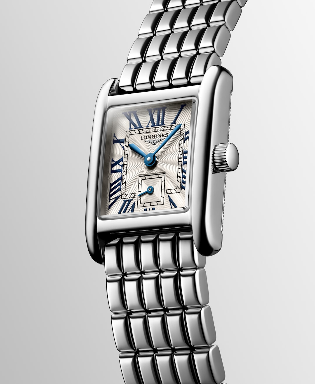 A Longines watch is displayed in the middle, tilted to the left on a white background. The rectangular-shaped watch features a silver dial, blue hands, black markers, a stainless steel bezel, and a stainless steel bracelet.