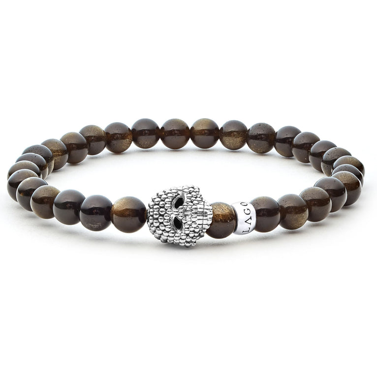 A sterling silver bracelet is displayed in the middle of a white background featuring a Golden Obsidian gemstone beaded bracelet with a sterling silver Caviar skull.