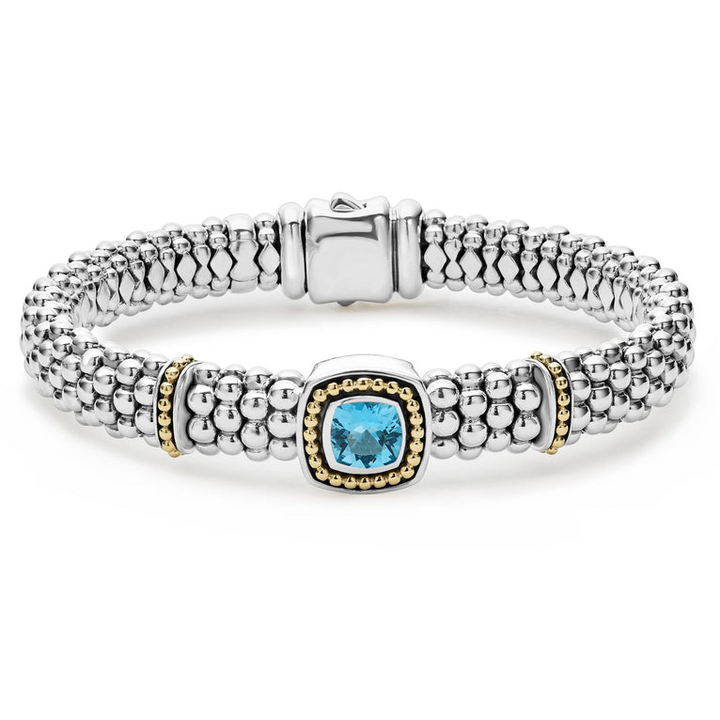 A sterling silver & 18k gold bracelet displayed in the middle of a white background featuring a Swiss blue topaz gemstone and sterling silver Caviar beading with 18K gold detailing.