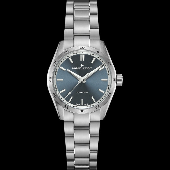 A Hamilton watch is laid out against a black background. It features a blue dial, silver hands and markers, a stainless steel bezel, and a stainless steel bracelet.