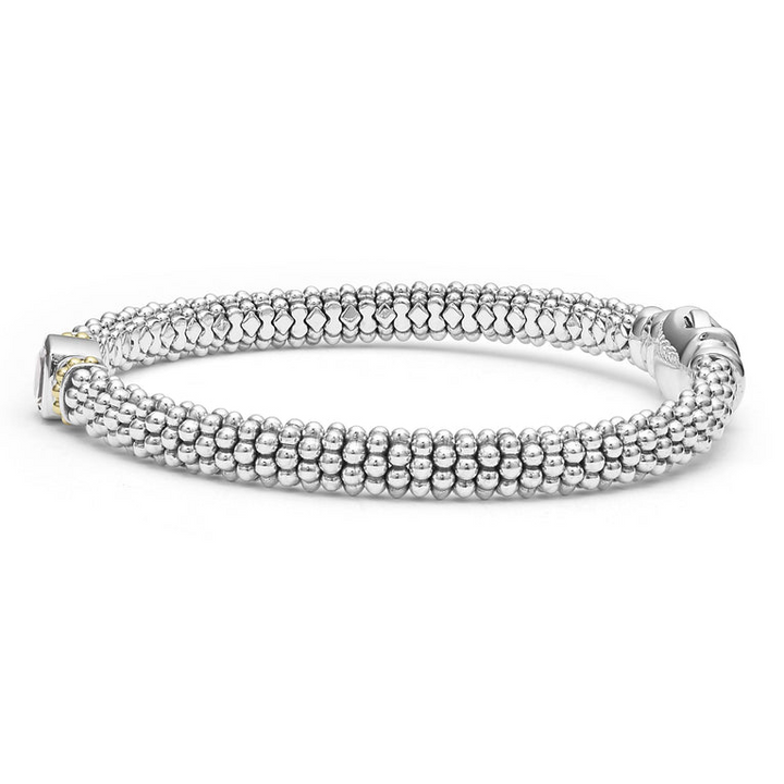 A side-view of a sterling silver bracelet in the middle of a white background features a white topaz gemstone and sterling silver Caviar beading with 18K gold detailing.