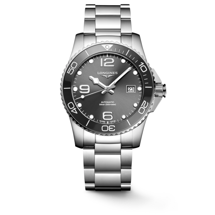 A Longines watch standing straight against a transparent background. The watch features a black dial, white hands and markers, a black bezel, a crown on the right, and a stainless steel bracelet.