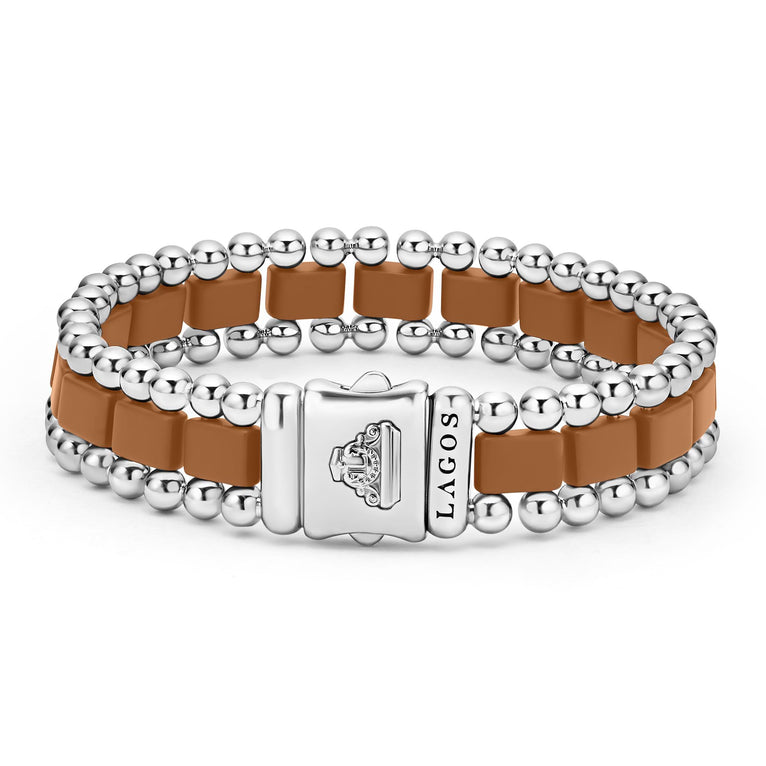 A back-view of a stainless steel bracelet in the middle of a white background featuring matte tan ceramic and caviar beading.