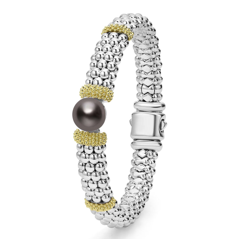 A sterling silver bracelet standing verticality in the middle of a white background featuring Tahitian black pearl accented by 18K gold stations and caviar beading.