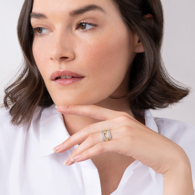 A woman is wearing a sterling silver and 18k gold ring featuring smooth stations of 18K gold set by sterling silver Caviar beading