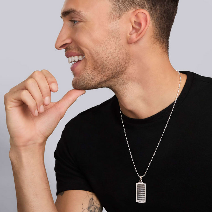 A man wearing a black shirt and a Caviar Beaded Tag Amulet with a chain necklace