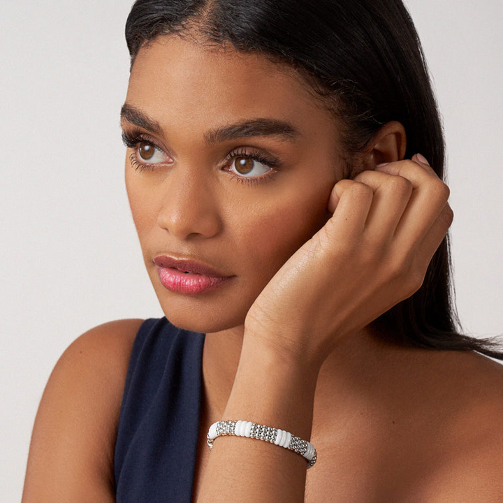 A woman is wearing sterling silver beaded bracelet, featuring Sterling silver Caviar beading and smooth white ceramic