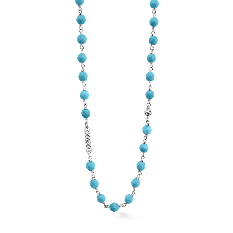 A close-up of a sterling silver and ceramic beaded necklace in the middle of a white background featuring Turquoise ceramic and silver Caviar beading.