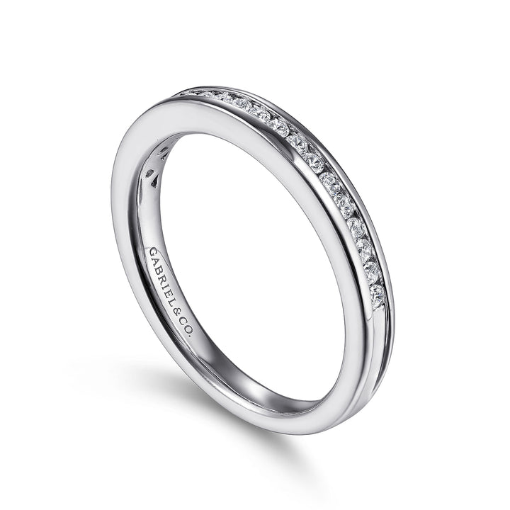 This is a close-up of a white gold ring angled to the right. It shows the inside of the band against a white background. The band features channel-set diamonds.