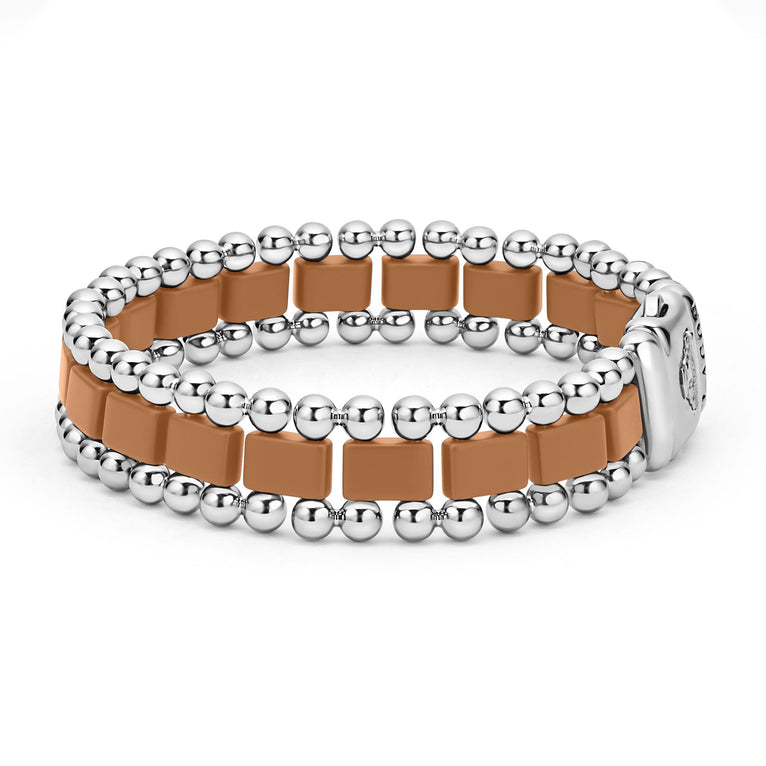 A side-view of a stainless steel bracelet in the middle of a white background featuring matte tan ceramic and caviar beading.