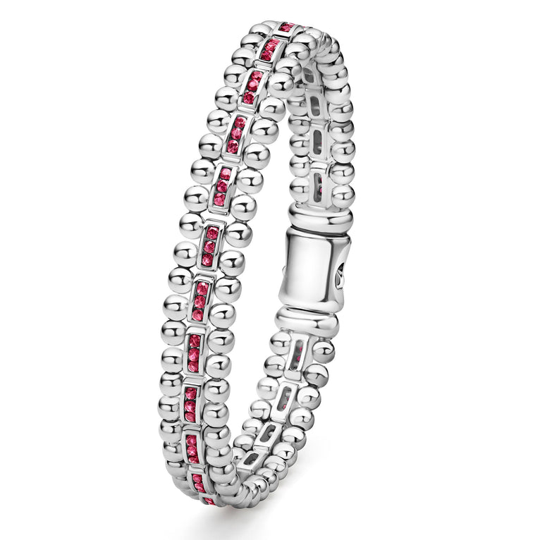 A side-view of a Sterling silver link bracelet in the middle of a white background featuring ruby gemstones and caviar bead links.