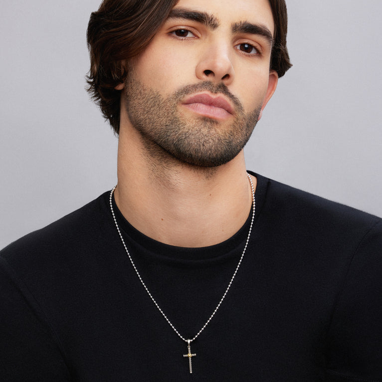 A man wearing a Two-Tone Caviar Beaded X Cross Amulet with a chain necklace