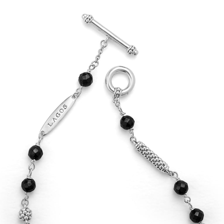 A sterling silver bracelet displayed in the middle of a white background focusing on the clasp featuring Black ceramic and sterling silver Caviar beads.