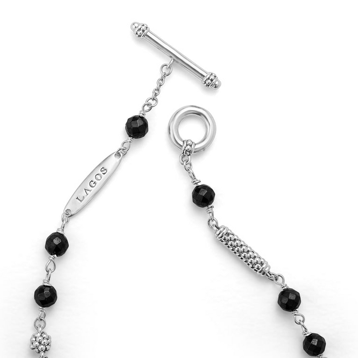 A sterling silver bracelet displayed in the middle of a white background focusing on the clasp featuring Black ceramic and sterling silver Caviar beads.