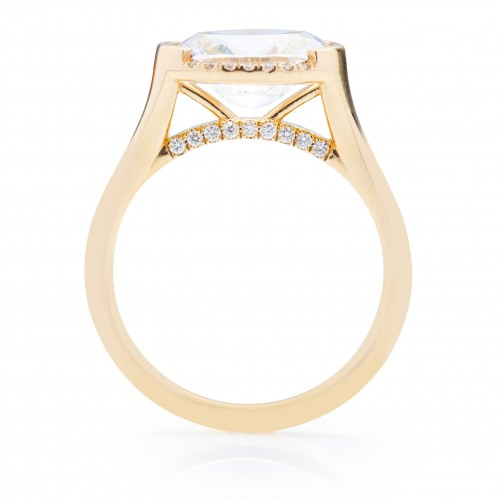 A side-view of the Oval East West Semi Halo Engagement Ring, made of yellow gold. The side view shows the diamond's pavilion and the yellow-gold band.