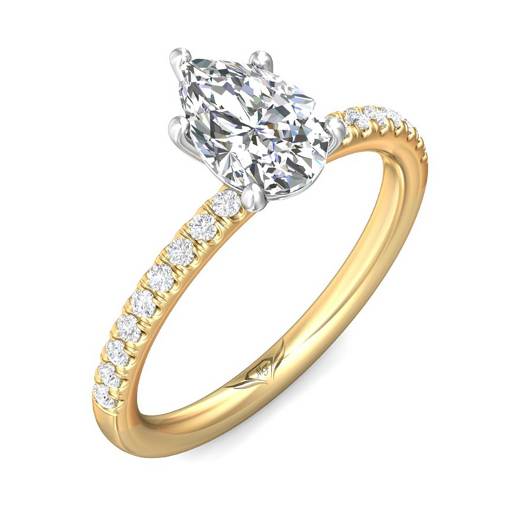 A close-up view of the Half Eternity Engagement Ring, made of yellow gold. The ring is angled against a white background to the right. It features a pear-cut diamond set in the center with a mircopave diamond set band. Showing the "Martin Flyer" inscription is visible inside the band.