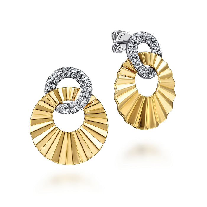 A pair of drop earrings with a circle diamond set diamond with an intertwined waved designed gold circle.