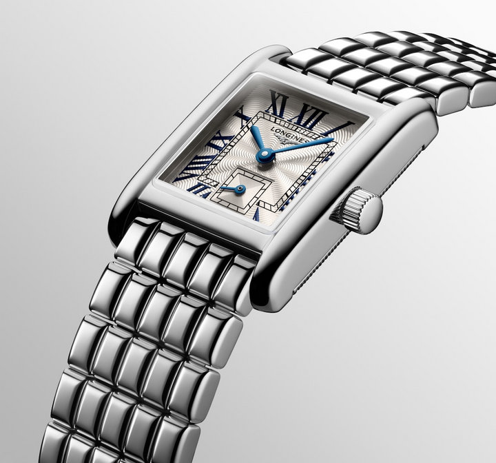 A Longines watch is displayed in the middle, angled to the right on a white background. The rectangular-shaped watch features a silver dial, blue hands, black markers, a stainless steel bezel, and a stainless steel bracelet.