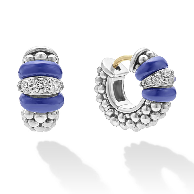 A pair of huggie earrings made of smooth ultramarine ceramic and diamonds with Caviar beading. The right earring is angled to the side. 