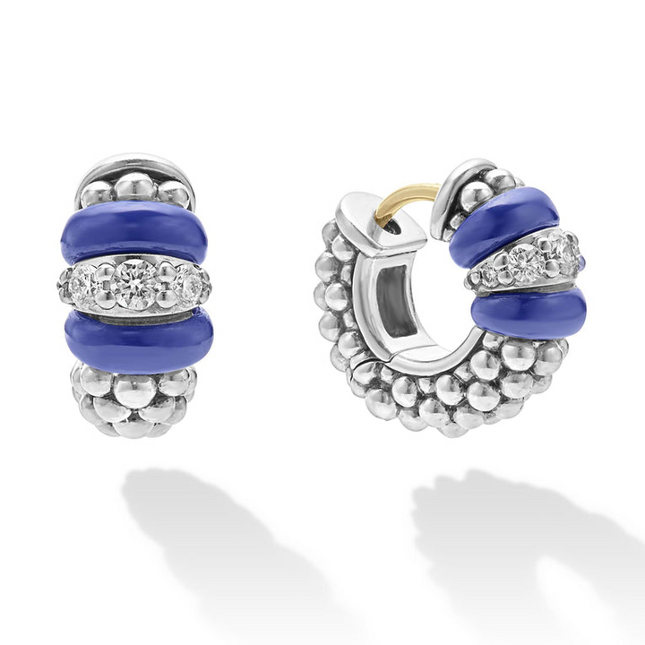 A pair of huggie earrings made of smooth ultramarine ceramic and diamonds with Caviar beading. The right earring is angled to the side. 