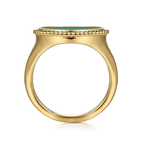 A close-up of a 14k yellow-gold ring resting vertically in the middle of a white background. The ring features a round malachite center stone surrounded by gold beads.