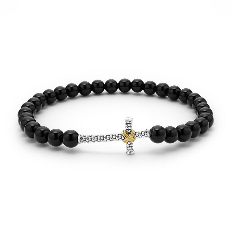 A Sterling Silver & 18K Gold stretch bracelet in the middle of a white background, featuring a Caviar beaded cross and onyx beading.