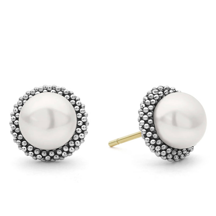 A pair of classic pearl stud earrings set in signature sterling silver Caviar beading. The right earring is angled to the side.