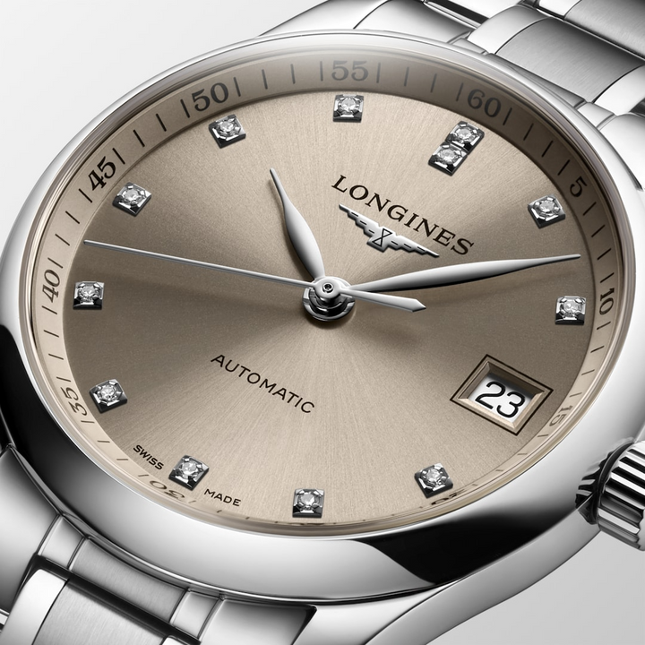 A close-up of a Longines watch highlighting the beige diamond-set dial and crown. 