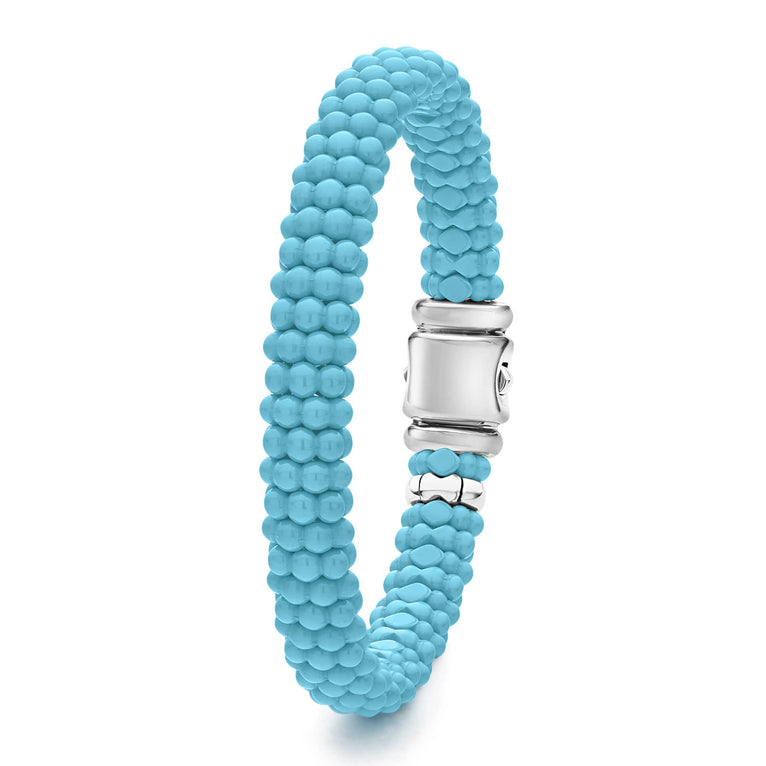 A sterling silver beaded bracelet standing vertically in the middle of a white background, featuring light blue ceramic caviar beading and a sterling silver box clasp.