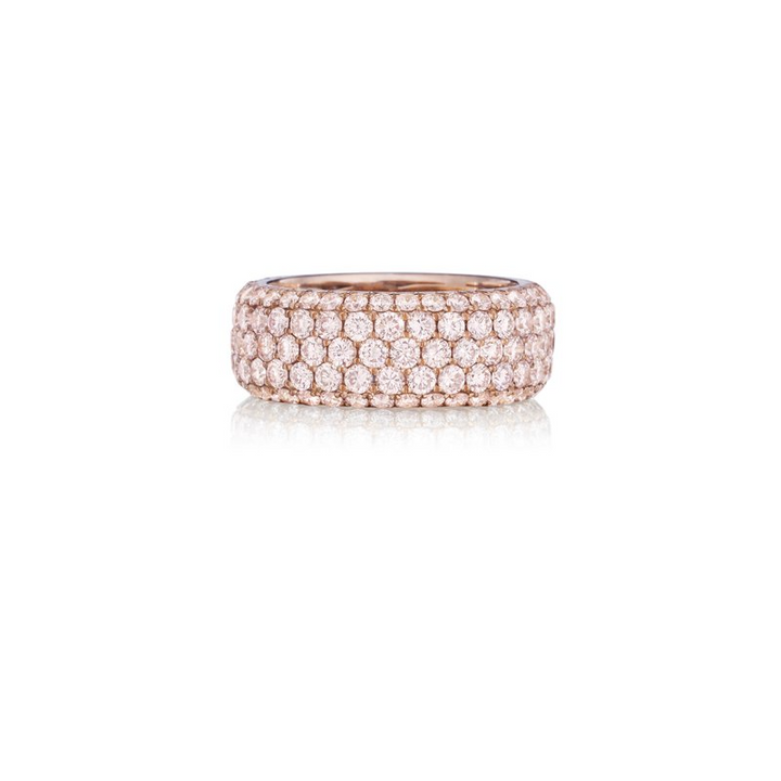 A rose-gold ring lies flat against a white background. It features a pave diamond-set wide band. 