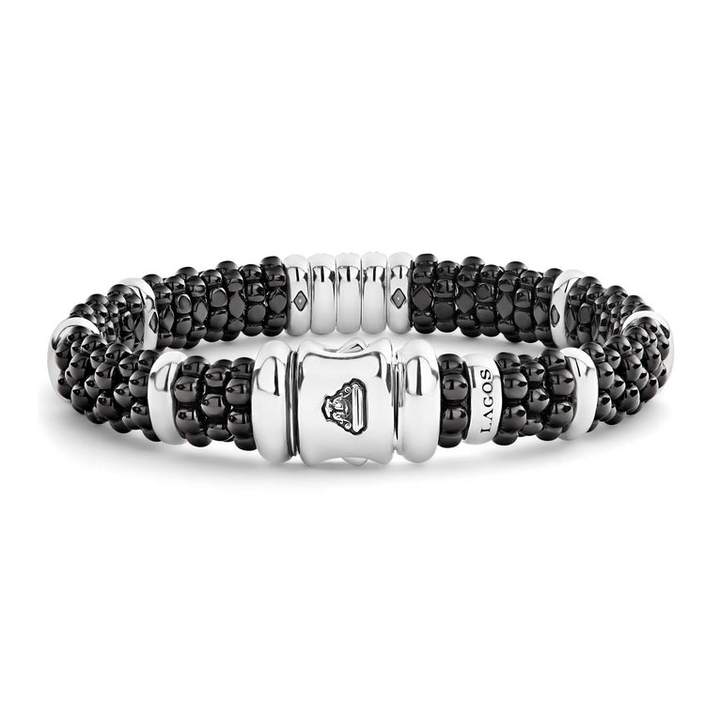 A sterling silver bracelet in the middle of a white background highlight the clasp, featuring three diamond stations, black ceramic caviar beading, and sterling silver stations