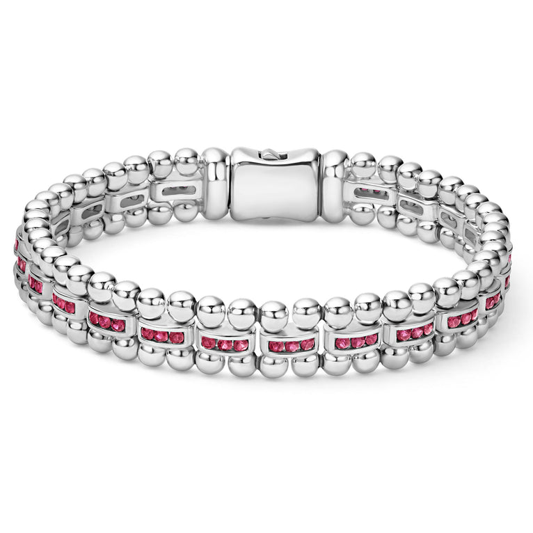 A Sterling silver link bracelet in the middle of a white background featuring ruby gemstones and caviar bead links.