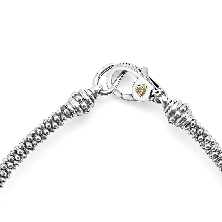 A close-up of a bracelet in the middle of a white background focusing on the clasp featuring three caviar spheres accent a sterling silver beaded strand