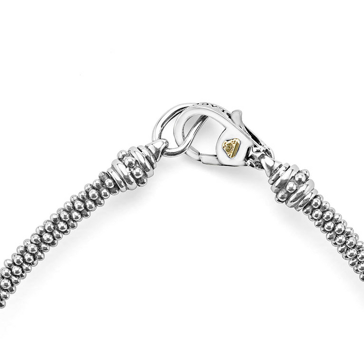 A close-up of a bracelet in the middle of a white background focusing on the clasp featuring three caviar spheres accent a sterling silver beaded strand