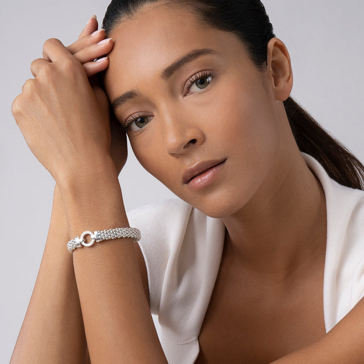 A woman is wearing sterling silver beaded bracelet, featuring a detailed circle motif and caviar beading