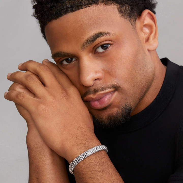 A man is wearing a sterling silver bracelet featuring skull caviar beading