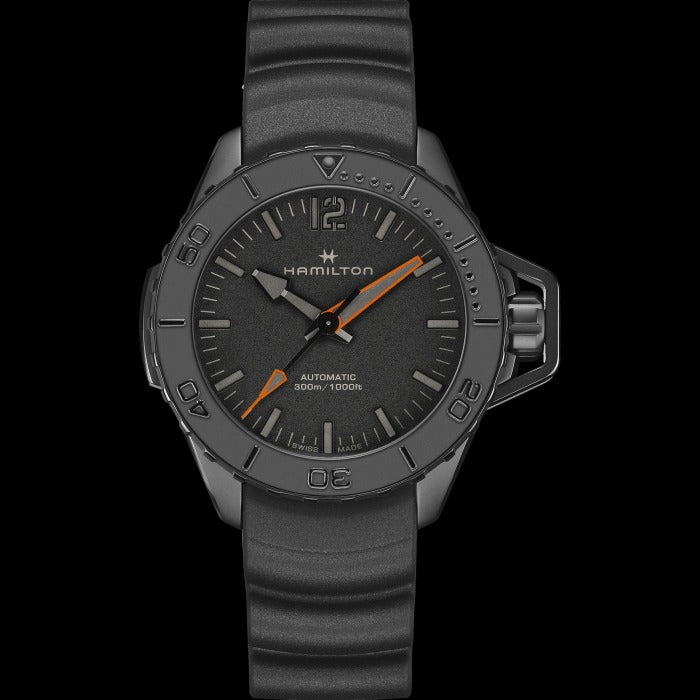 A Hamilton watch is laid out against a black background. It features a black dial, white hands and markers, a PVD black coating steel case, a steel bezel, a steel crown, and a rubber strap.