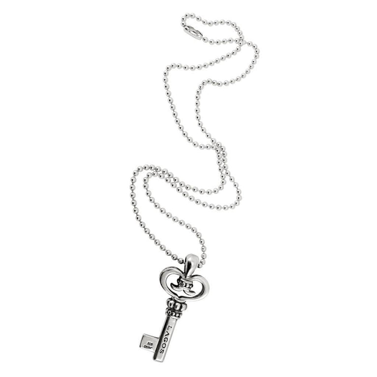 A sterling silver necklace in the middle of the white background featuring a key pendant with Caviar beading, fluted accents, the LAGOS logo, and crest finished on a ball chain necklace