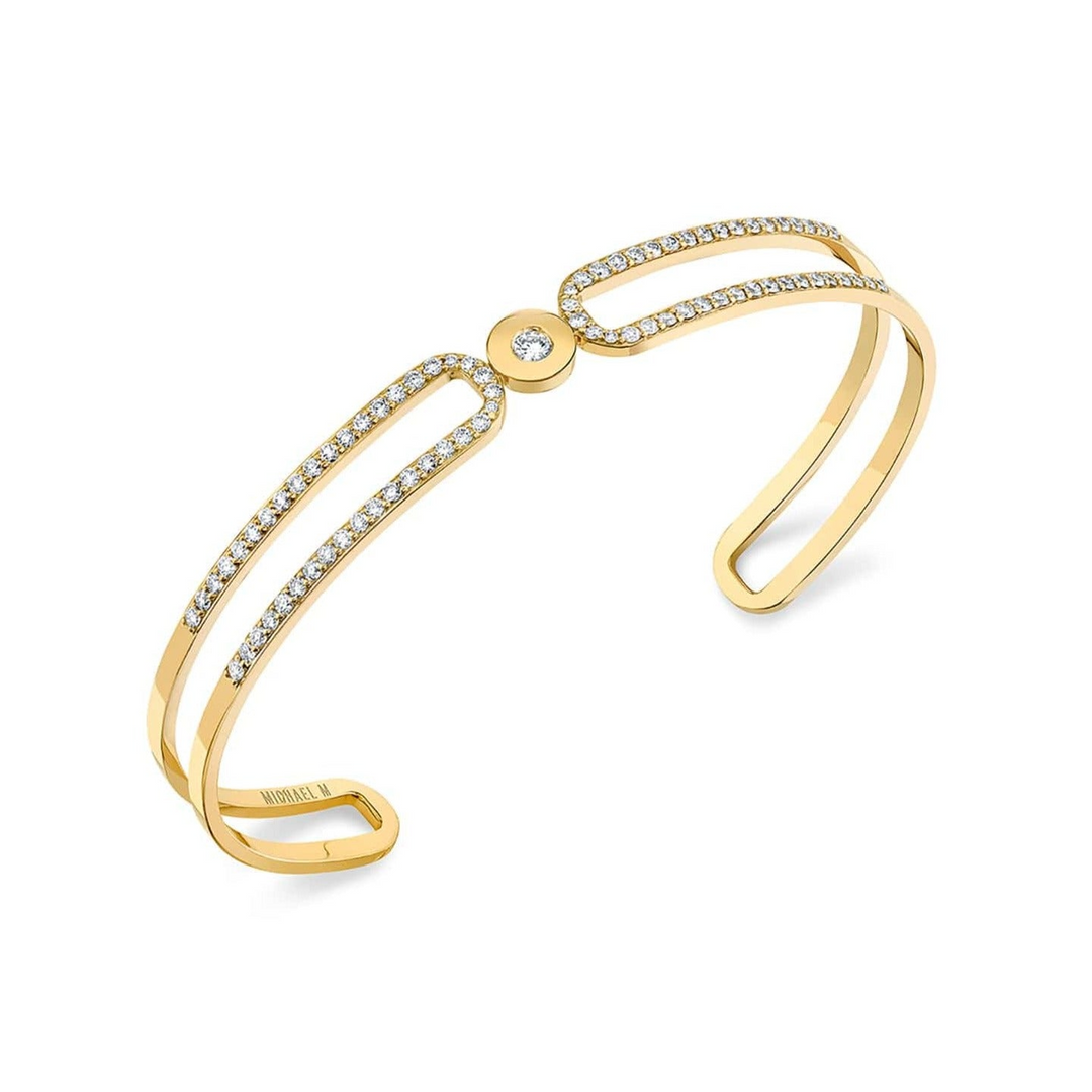 A yellow-gold bracelet lying flat, angled to the right against a white background, features a paved double-banded cuff bracelet.